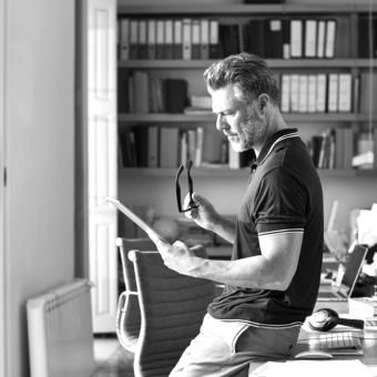 Man leaning against desk with tablet