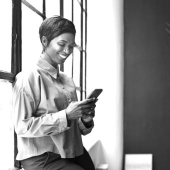 Smiling entrepreneur using phone in office