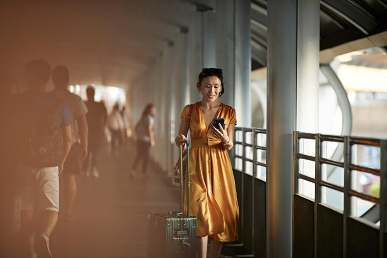 femme en train de voyager et consulter son smartphone